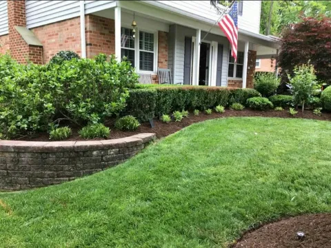A front yard with fresh mulch in the beds and a newly mown lawn.